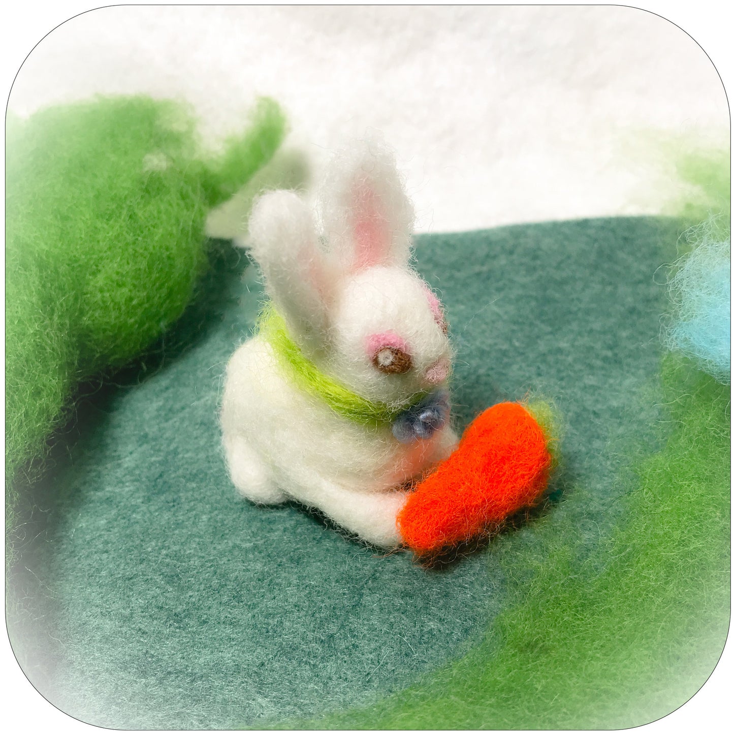 Needle felted white bunny with a carrot.